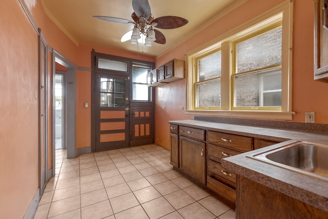 kitchen featuring crown molding, ceiling fan, a healthy amount of sunlight, and light tile patterned floors