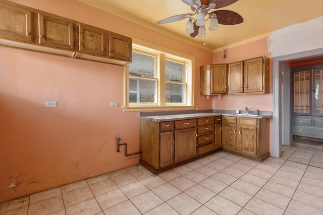 kitchen featuring ornamental molding, sink, light tile patterned floors, and ceiling fan