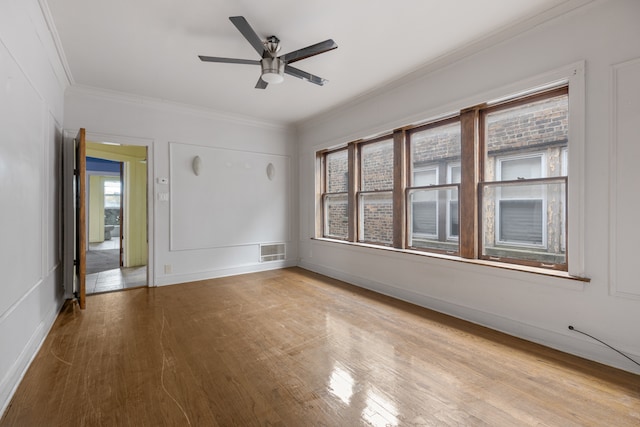 spare room with ceiling fan, ornamental molding, and light wood-type flooring