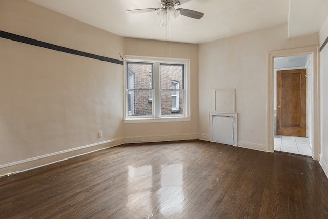 empty room with dark hardwood / wood-style floors and ceiling fan