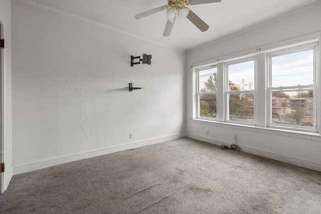 unfurnished room with ornamental molding, carpet, and ceiling fan