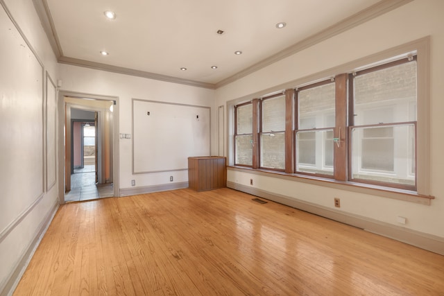 unfurnished room featuring light hardwood / wood-style flooring and crown molding