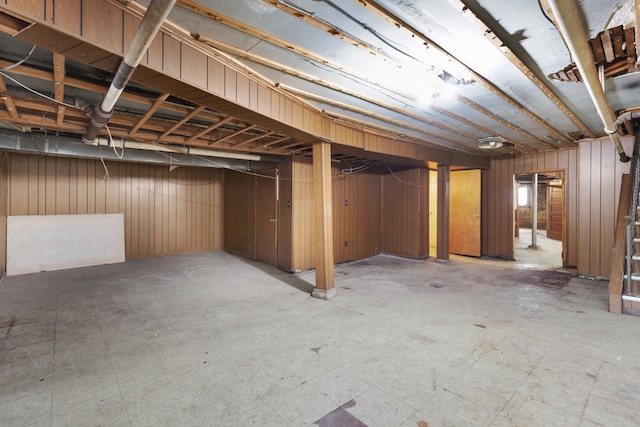 basement featuring wood walls