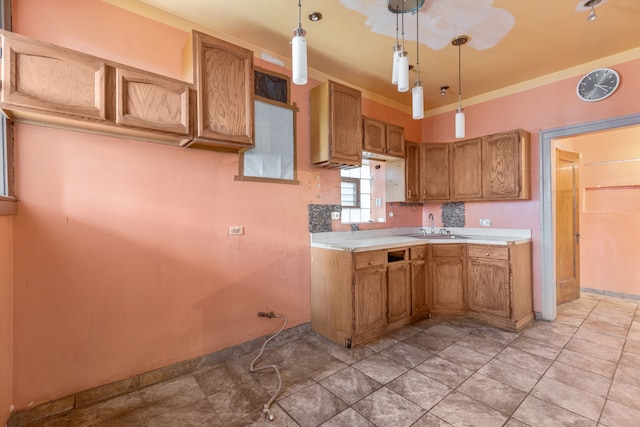 kitchen with crown molding, decorative light fixtures, and sink