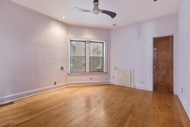 empty room with hardwood / wood-style floors, crown molding, and ceiling fan