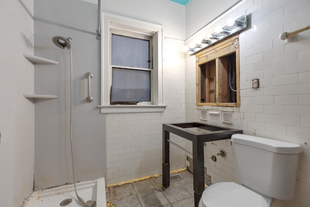 bathroom with toilet, walk in shower, and tile walls