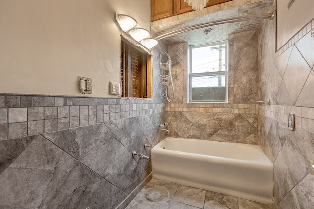 bathroom with tiled shower / bath combo and tile walls