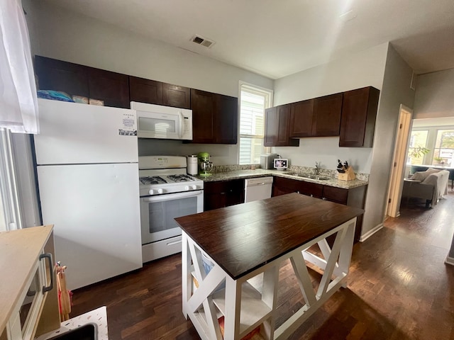 kitchen with sink, dark brown cabinetry, white appliances, and dark wood-type flooring