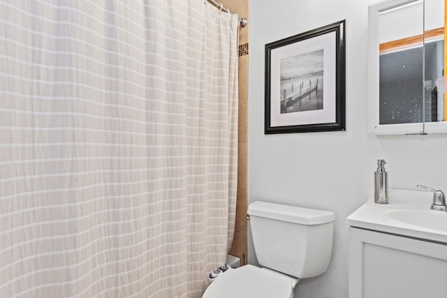 bathroom featuring toilet, vanity, and a shower with shower curtain