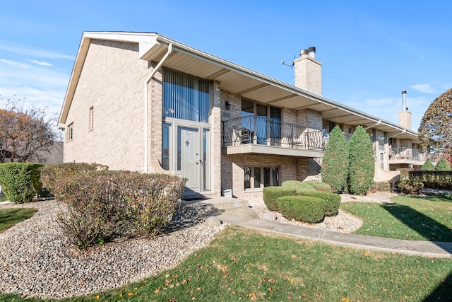 exterior space with a lawn and a balcony