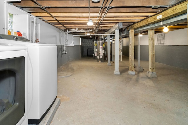 basement featuring heating unit, washing machine and clothes dryer, and gas water heater