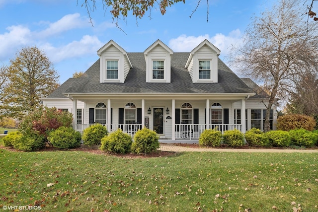 cape cod house with a front lawn and covered porch