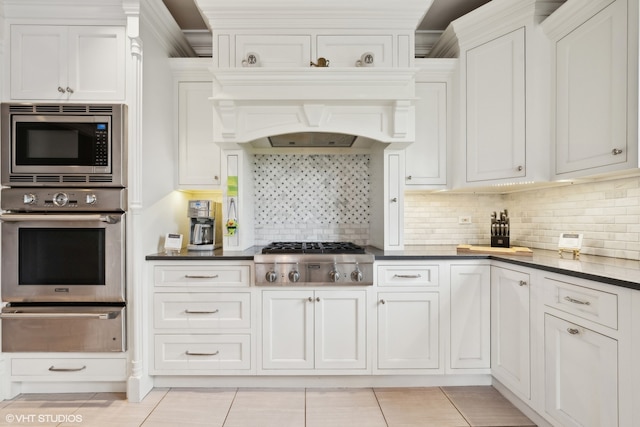 kitchen featuring decorative backsplash, white cabinetry, and stainless steel appliances