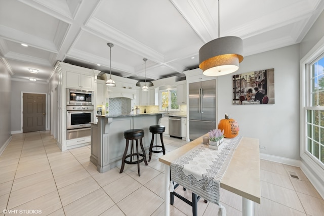 kitchen featuring decorative backsplash, a kitchen island, white cabinetry, built in appliances, and pendant lighting