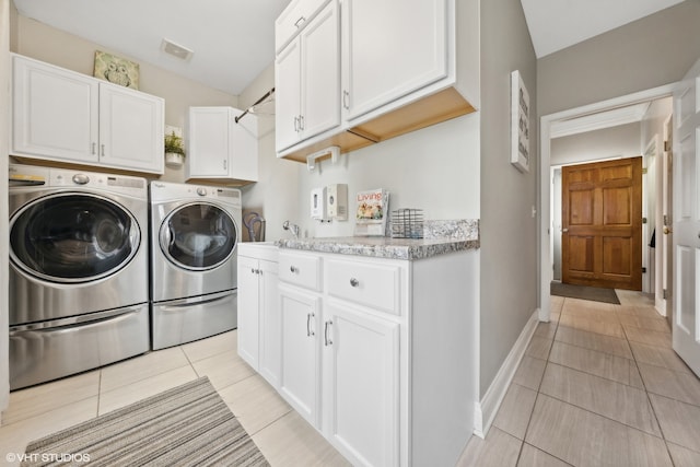 laundry room featuring sink, washer and dryer, light tile patterned floors, and cabinets