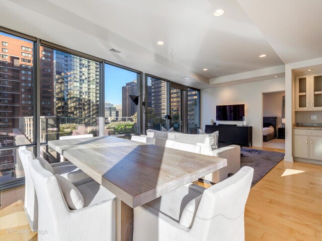 dining space featuring light wood-type flooring and expansive windows