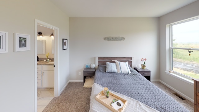 bedroom with light carpet and ensuite bath