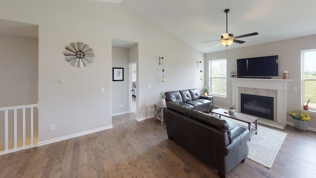 living room featuring lofted ceiling, dark wood-type flooring, a fireplace, and ceiling fan