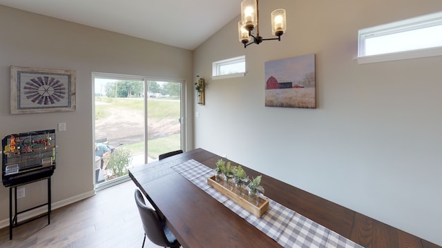 dining space with light hardwood / wood-style floors, vaulted ceiling, and a chandelier