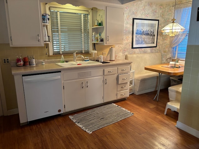 kitchen featuring white cabinetry, dishwasher, decorative light fixtures, and sink