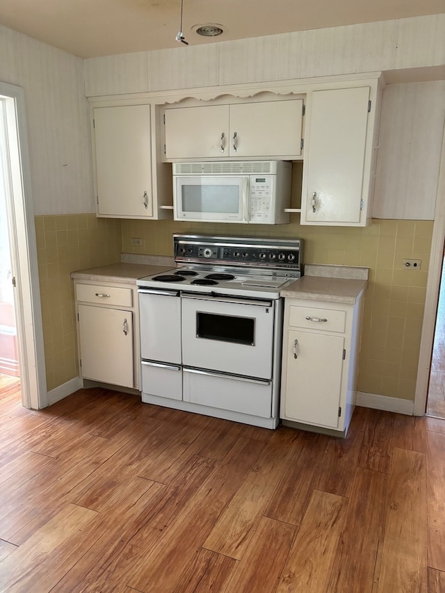 kitchen with light hardwood / wood-style flooring, white cabinetry, and white appliances