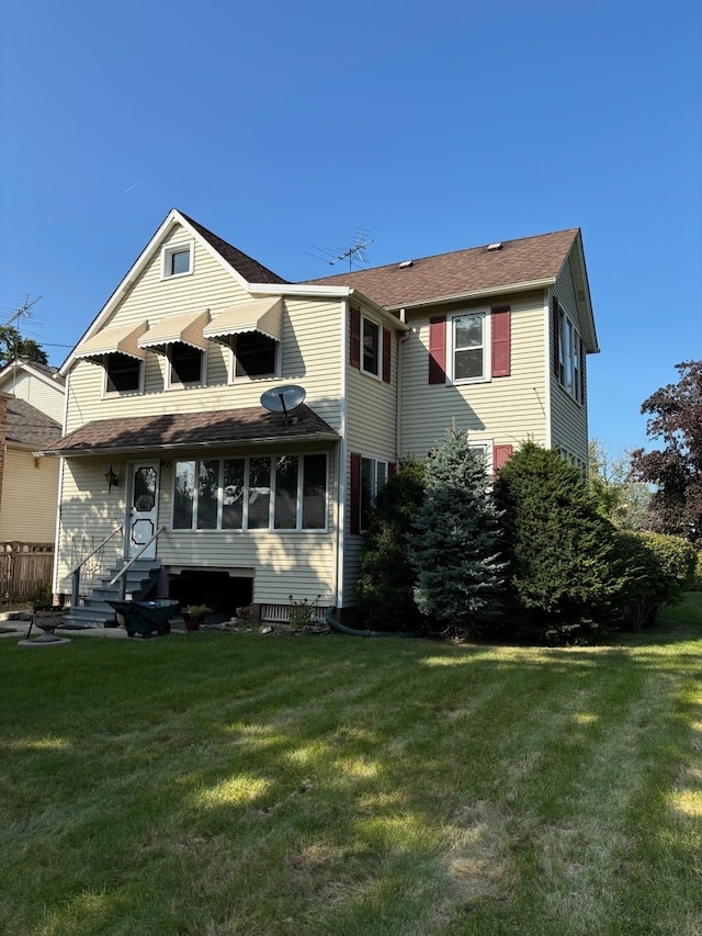 rear view of property featuring a yard