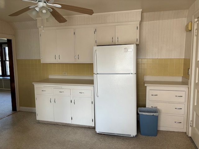 kitchen with ceiling fan, light carpet, tile walls, white cabinets, and white refrigerator