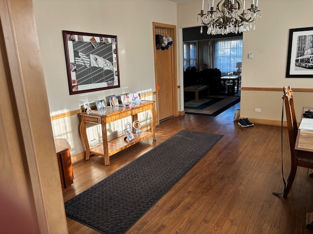 hallway featuring dark wood-type flooring and an inviting chandelier