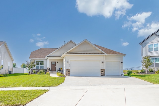 craftsman-style home with a front lawn, central AC unit, and a garage