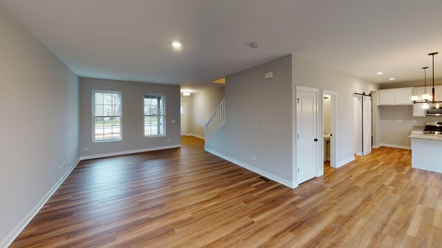 empty room featuring light hardwood / wood-style floors and a barn door