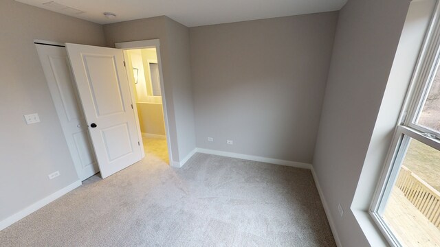 unfurnished bedroom with light colored carpet