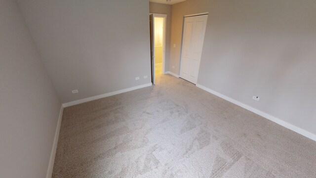 unfurnished room featuring light colored carpet