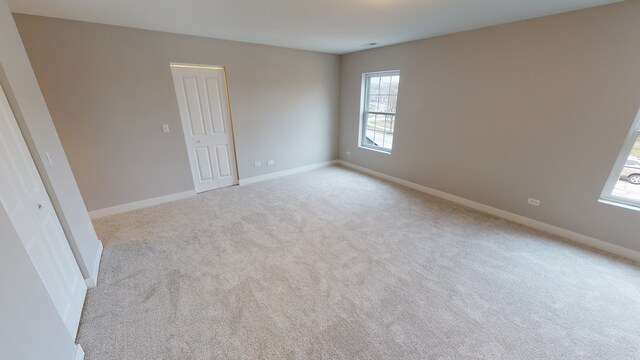 spare room featuring light carpet and a healthy amount of sunlight