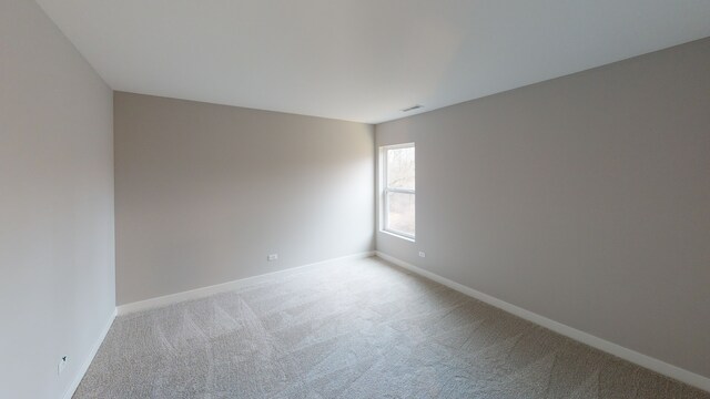 spare room featuring light colored carpet