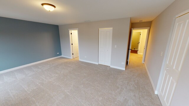 unfurnished bedroom featuring light carpet