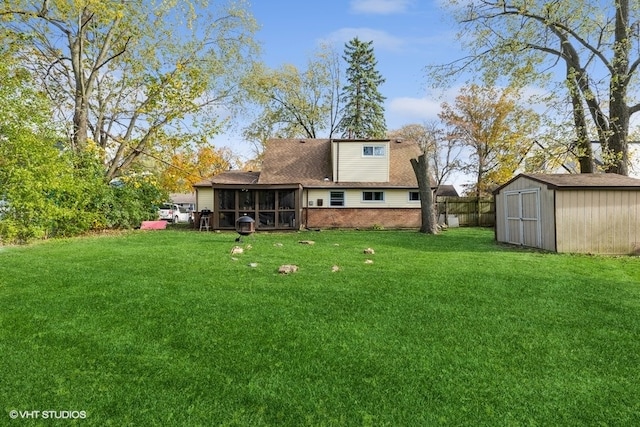 rear view of house with a yard, a sunroom, and a shed