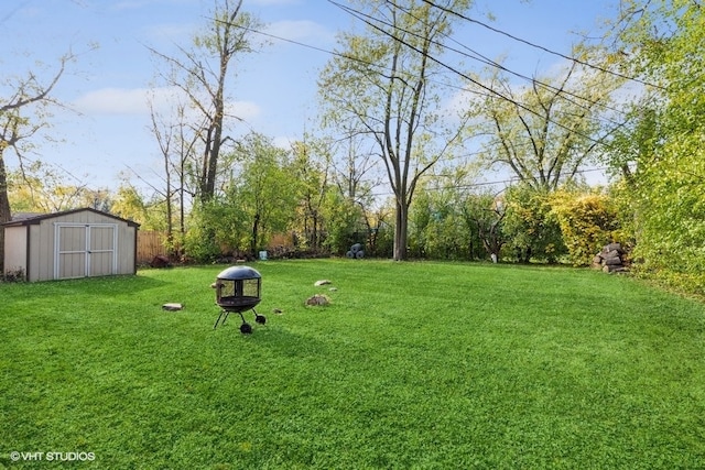 view of yard featuring a storage shed and an outdoor fire pit