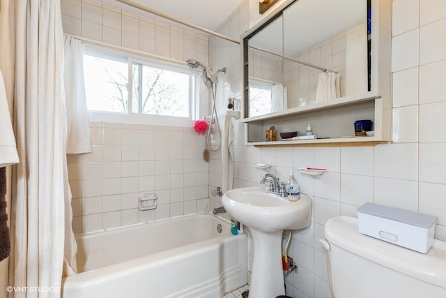 bathroom featuring toilet, tasteful backsplash, shower / bathtub combination with curtain, and tile walls