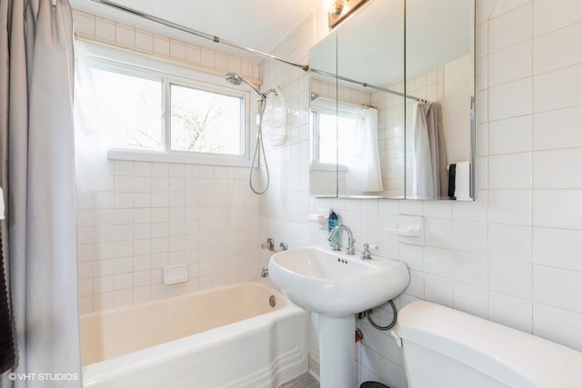 bathroom featuring backsplash, tile walls, shower / bath combo with shower curtain, and toilet