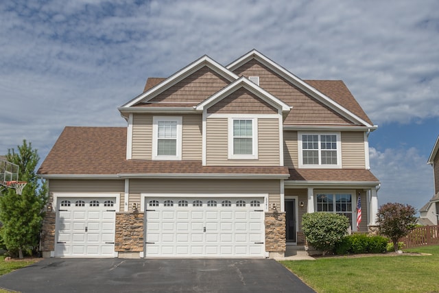 craftsman house with a garage and a front lawn