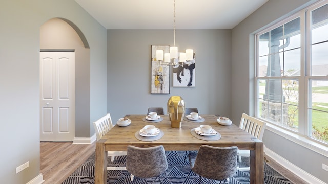 dining space featuring a notable chandelier and light wood-type flooring