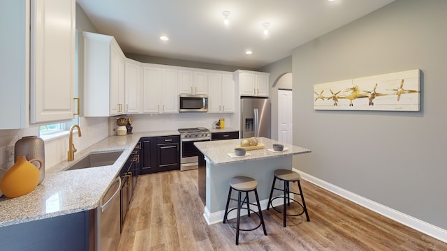 kitchen featuring white cabinetry, light hardwood / wood-style floors, appliances with stainless steel finishes, and a kitchen island