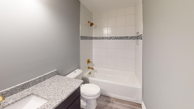 full bathroom with vanity, toilet, hardwood / wood-style flooring, and tiled shower / bath