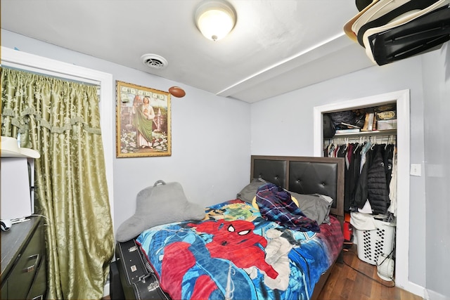 bedroom with dark wood-type flooring and a closet