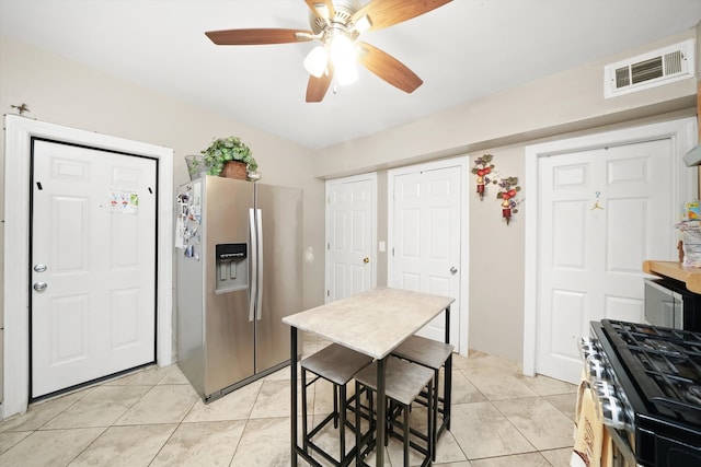 kitchen with stainless steel appliances, light tile patterned flooring, and ceiling fan