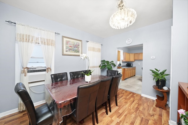 dining space with light hardwood / wood-style floors and a notable chandelier