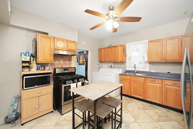 kitchen featuring sink, light tile patterned floors, ceiling fan, appliances with stainless steel finishes, and independent washer and dryer