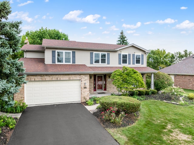 view of front of home with a front yard and a garage