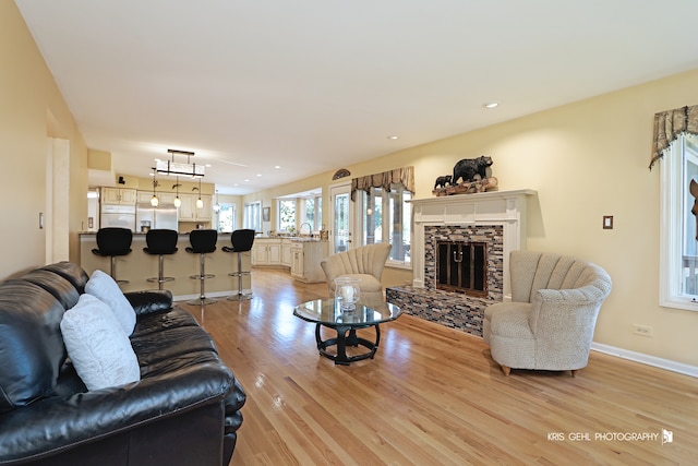 living room featuring light hardwood / wood-style floors, sink, and a fireplace