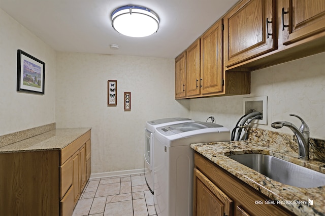 washroom with light tile patterned flooring, cabinets, sink, and separate washer and dryer